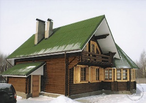 Бревенчатый дом с зеленой крышей