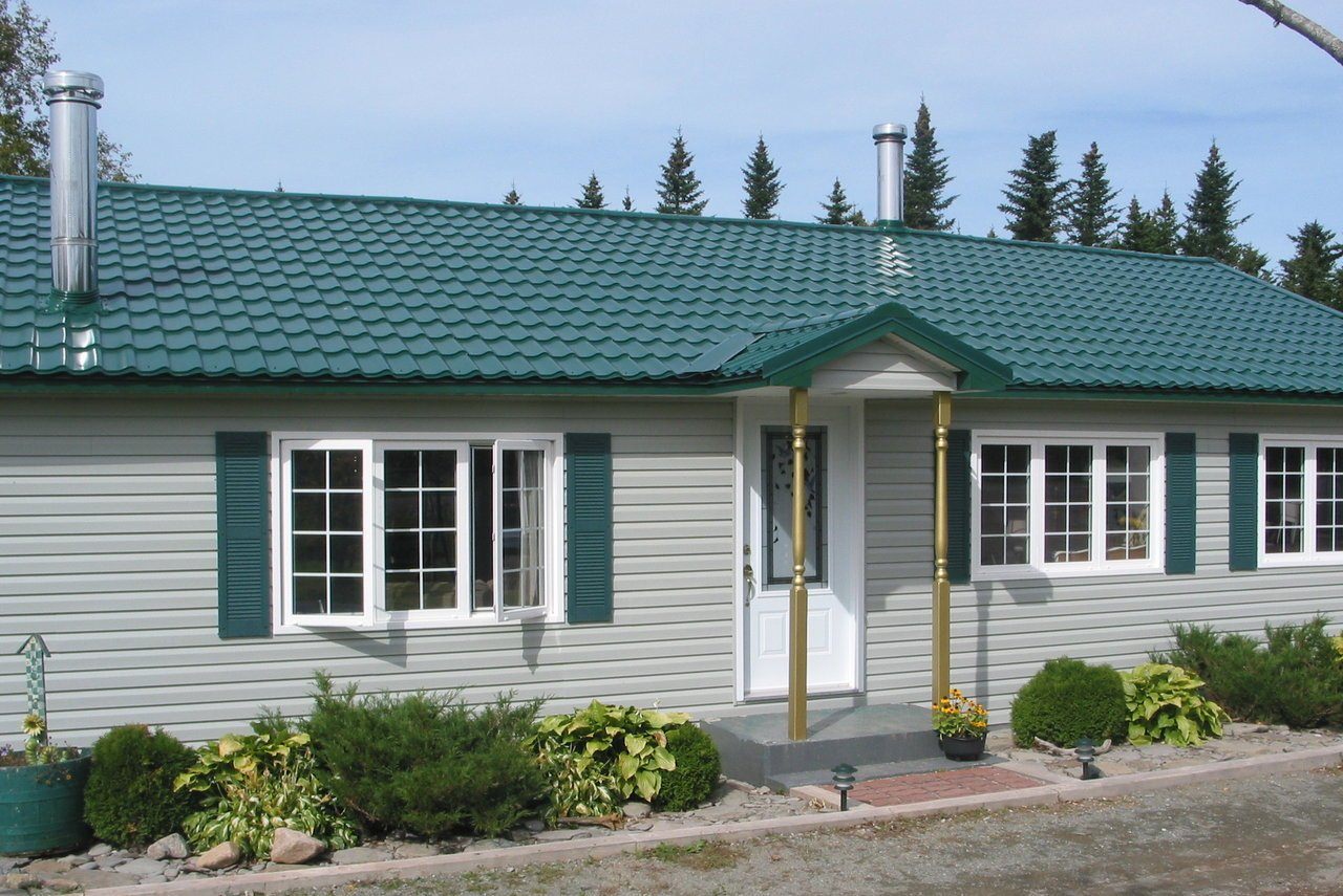 серый дом с зеленой крышей