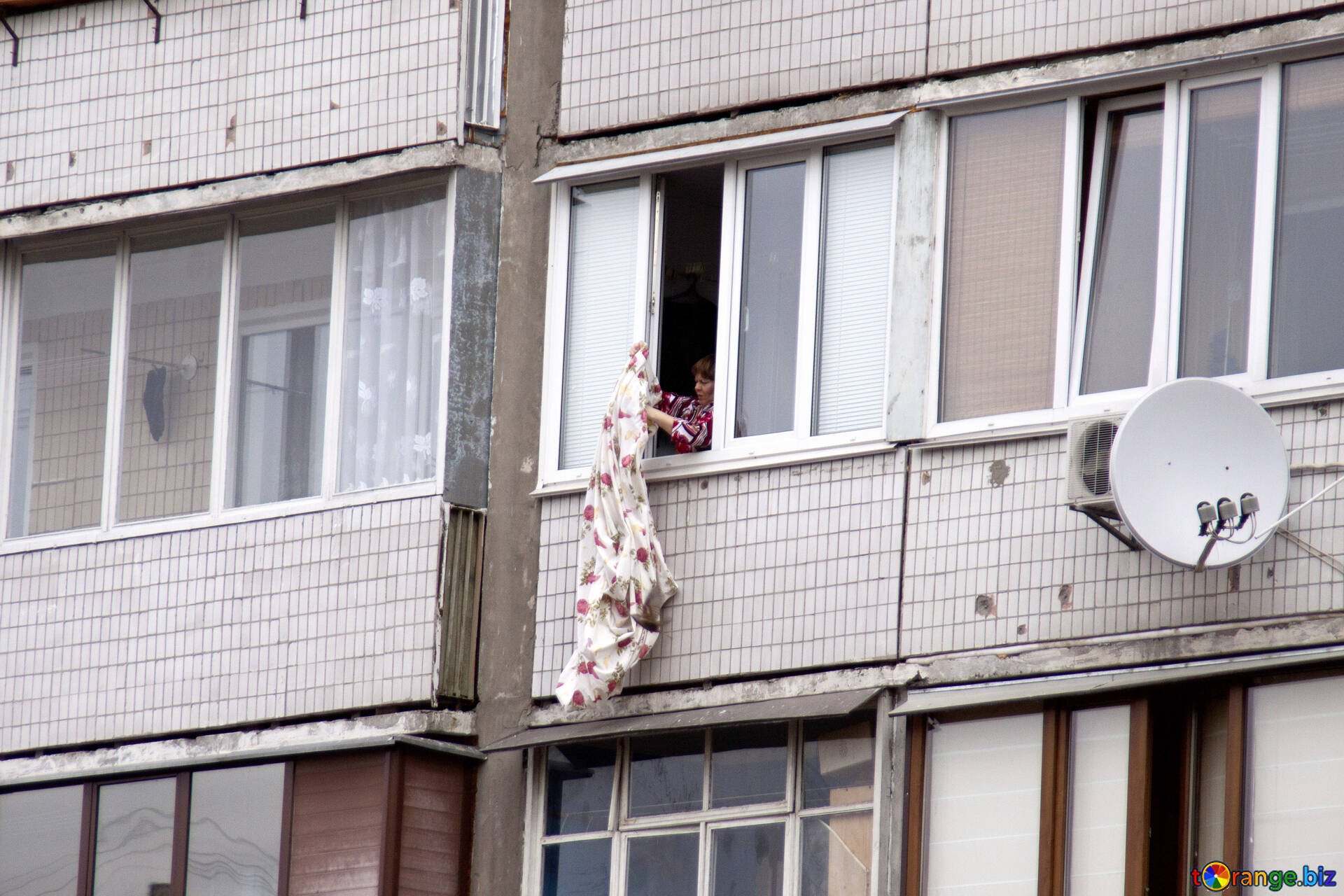 Соседка в окне. Подсмотренное в окнах домов. Вытряхивать с балкона. В окне дома напротив.